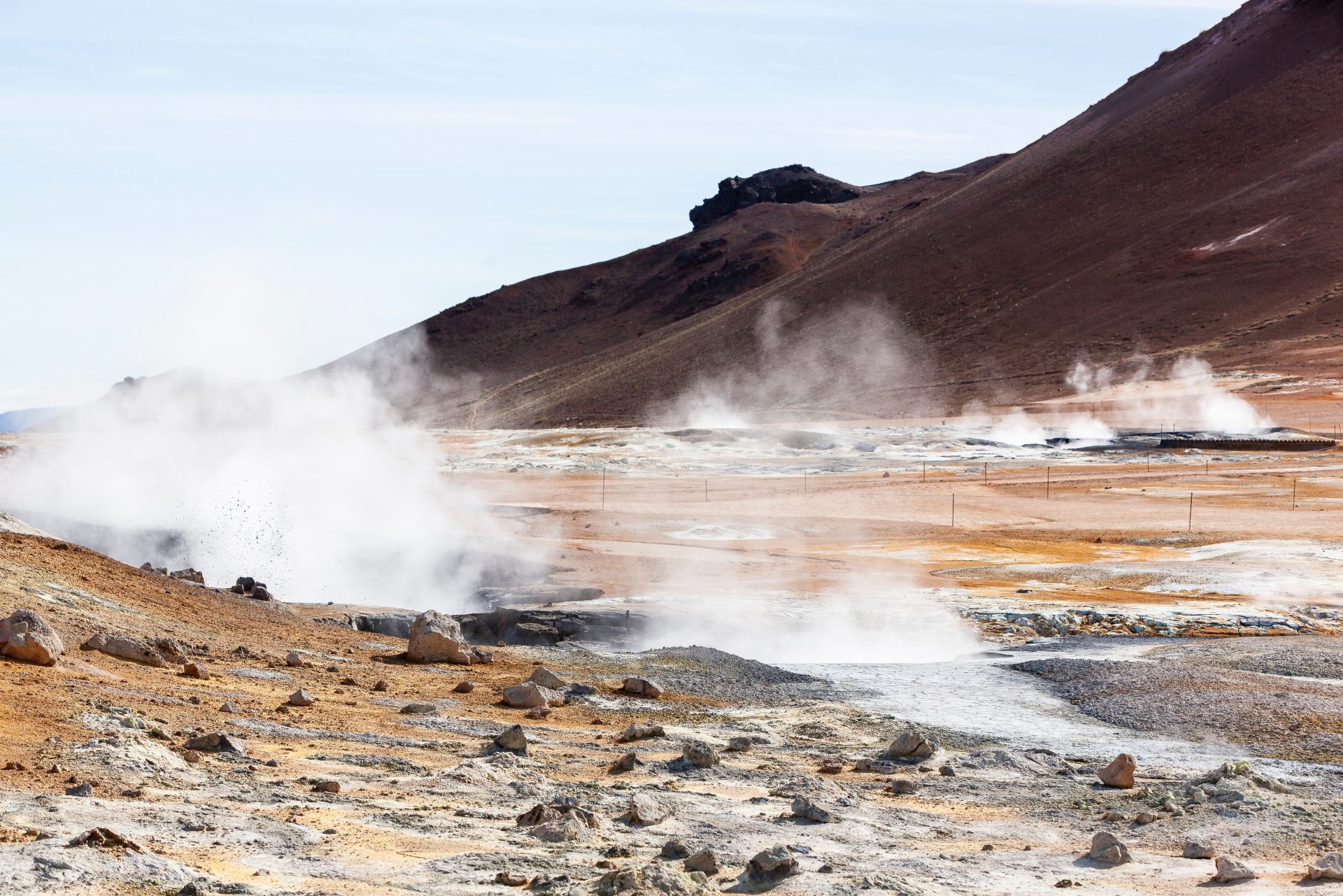 Parque Nacional Hverir en Islandia. Fumarolas saliendo de la superficie terrestre y una montaña al fondo.