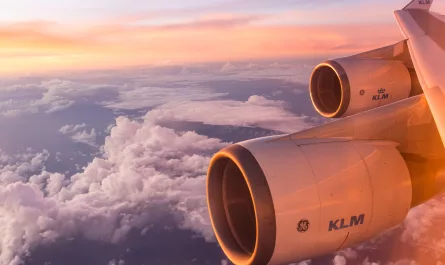turbina de un avión de KLM en pleno vuelo con el cielo del atardecer de fondo.