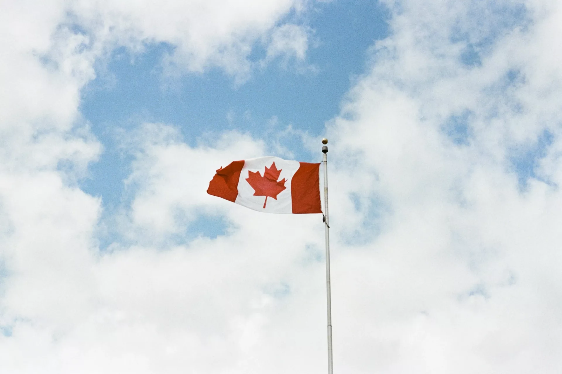bandera de canadá ondeando en el aire. Foto ilustrativa de nota de cómo ir a Canadá siendo mexicano.